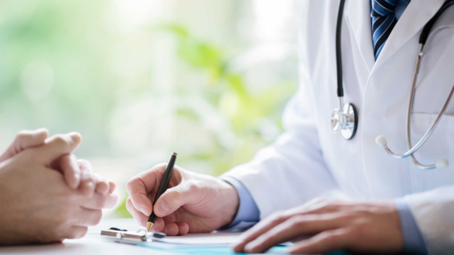 Cosmetic Procedures Doctor taking notes while consulting with patient